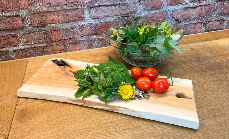 Frische Kräuter und Tomaten auf Holzbrett