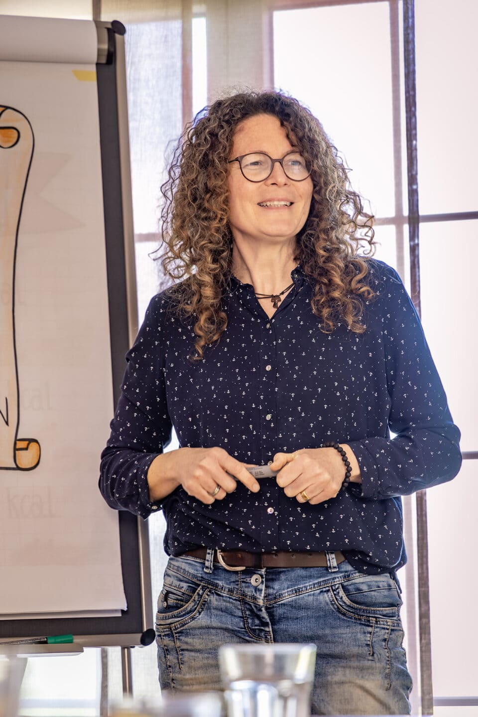 Person hält Präsentation vor Tafel