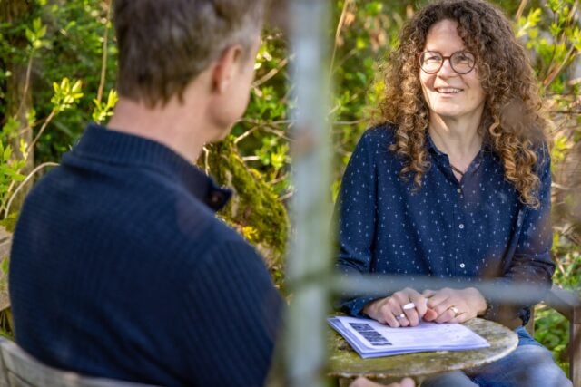 Zwei Personen reden lachend im Garten